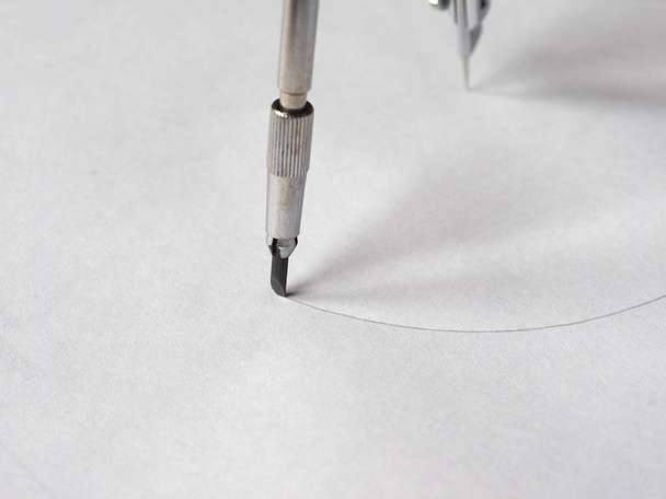 Instrumento de desenho técnico de bússola utilizado para a inscrição de círculos ou arcos em papel - foco seletivo em lápis
 - Foto, Imagem