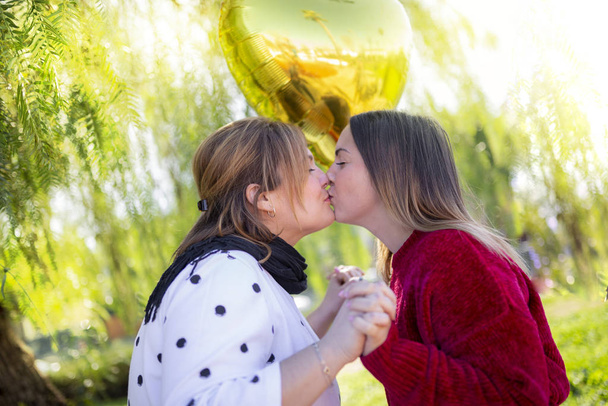лесбийская пара влюблённая целуется в парке на открытом воздухе
 - Фото, изображение