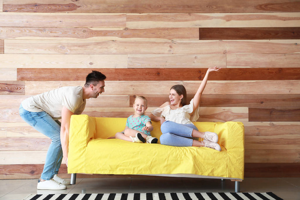 Young man trying to move sofa with sitting wife and daughter - Photo, image