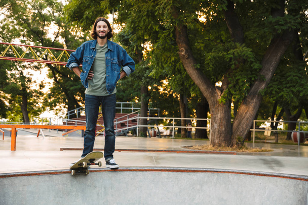 Handsome young hipster man skating on a skate ramp - Photo, image