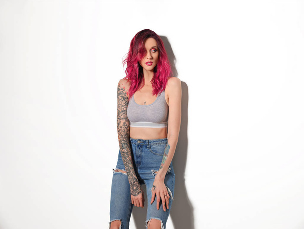 Beautiful woman with tattoos on body against light background - Fotó, kép