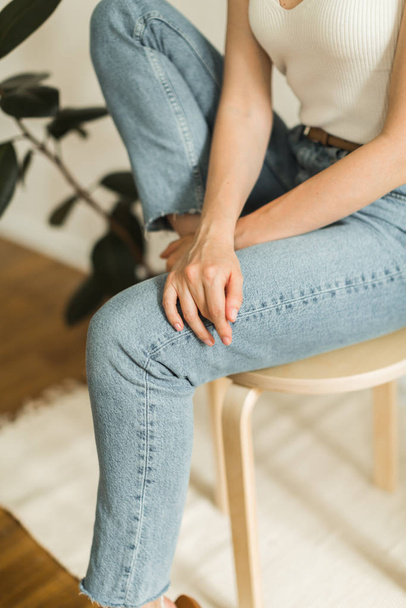 girl in blue jeans sits on a chair - Fotografie, Obrázek