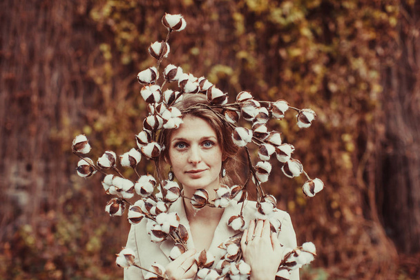 Woman holding branch of cotton flowers on nature background - Φωτογραφία, εικόνα