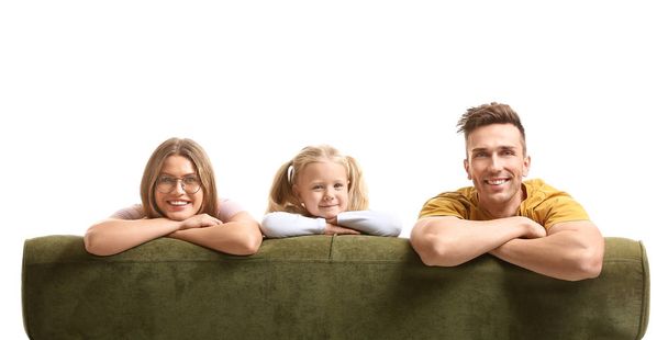 Happy young family sitting on sofa against white background - Valokuva, kuva