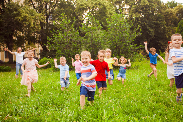 Gran grupo de niños corriendo en el parque
 - Foto, imagen