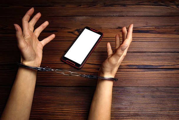 phone with hands addiction on a wooden background - 写真・画像