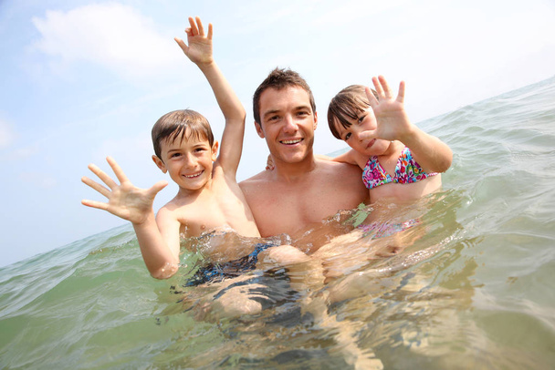 Man with children enjoying sea bath - Фото, зображення