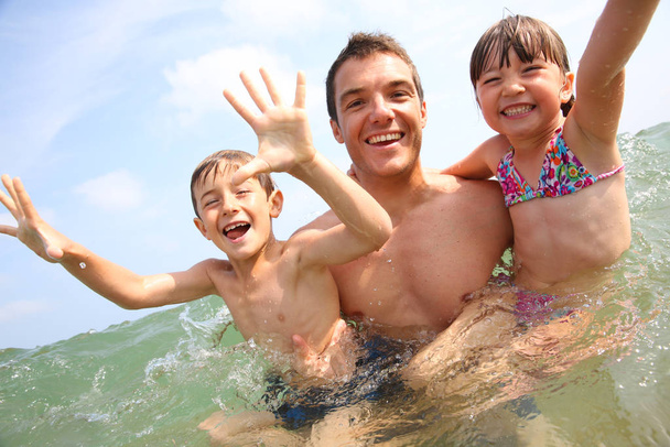 Man with children enjoying sea bath - Foto, Imagem