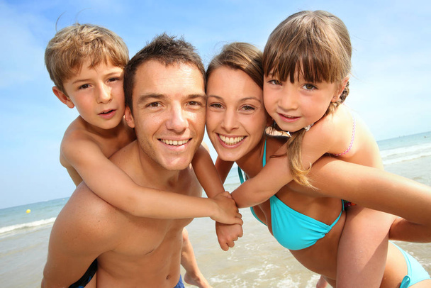 Portrait of happy family at the beach - 写真・画像