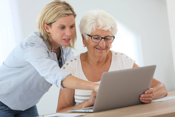 Homecarer with elderly woman using laptop computer - Photo, Image