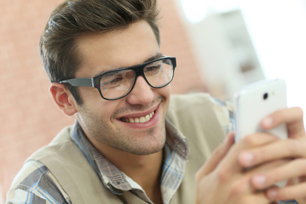 Young man connected on internet with smartphone - Photo, image