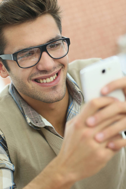 Young man connected on internet with smartphone - Foto, Imagem