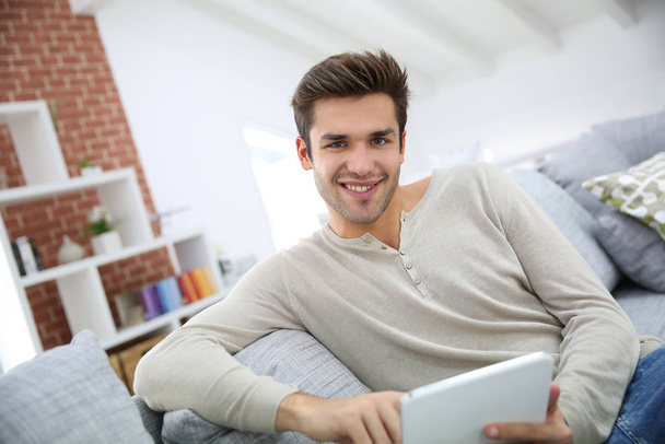 Man sitting in couch and websurfing on internet - Photo, image