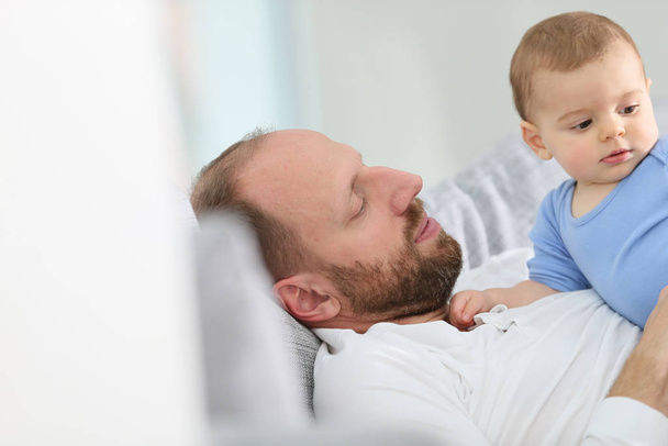 Father with baby boy relaxing in sofa at home - Photo, Image
