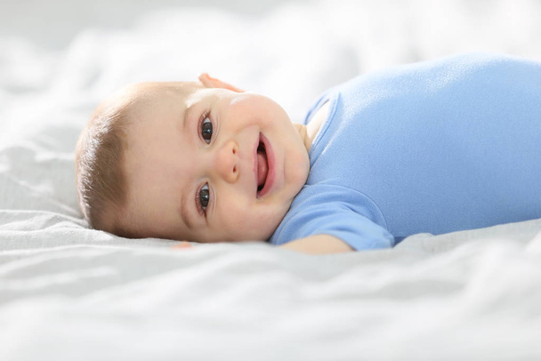 8-month-old baby boy laying on bed - Фото, изображение