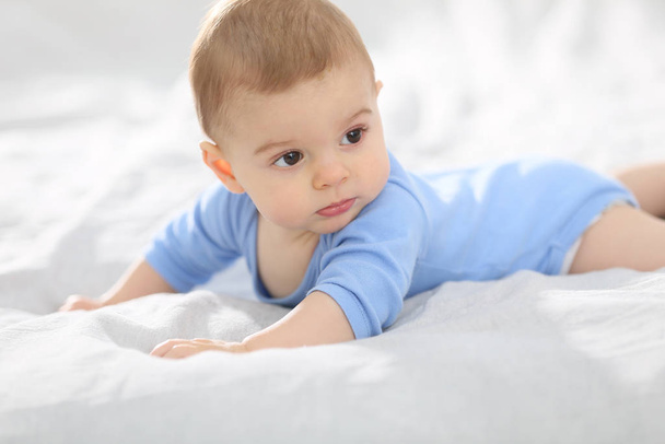 8-month-old baby boy laying on bed - Fotoğraf, Görsel