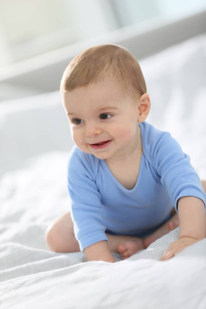 Cute baby boy sitting on bed - Photo, Image