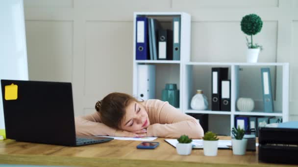 Girl sleeping in office and coworker throwing paper ball in her head - Video, Çekim
