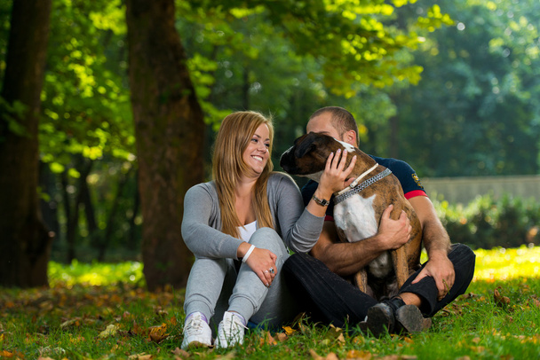 Couple Sitting Outdoors With Her Pet Dog German Boxer - Fotoğraf, Görsel