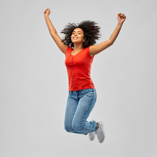 hymyilevä afrikkalainen amerikkalainen nainen mies hyppii ilmassa
 - Valokuva, kuva