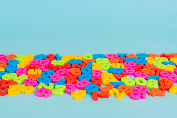Colorful plastic numbers on blue surface with copy space - 写真・画像