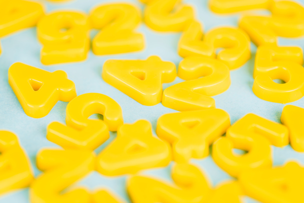 Selective focus of yellow plastic numbers on blue background - Photo, Image