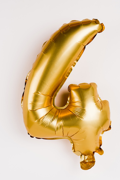 Festive golden balloon in shape of four number on grey background - Foto, imagen