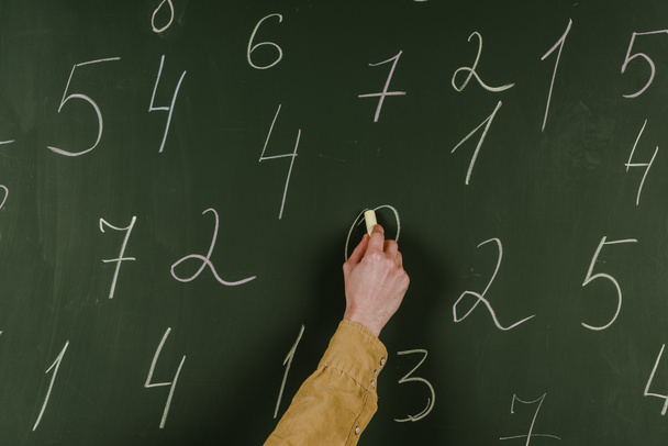 Vista recortada del hombre escribiendo números con tiza en pizarra
 - Foto, Imagen