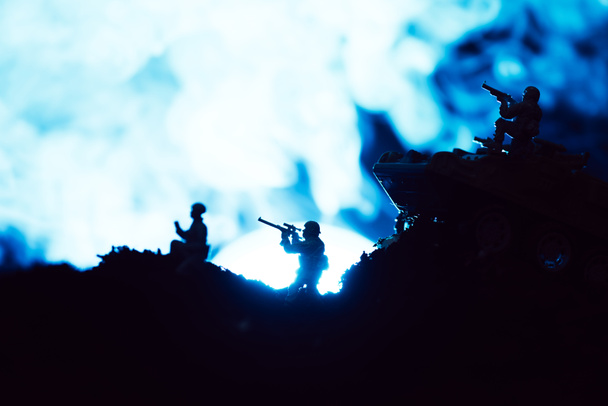 Oyuncak askerlerle savaş sahnesi ve siyah arka planda ay ile duman. - Fotoğraf, Görsel