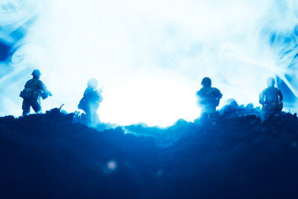 Battle scene with toy warriors in smoke on blue background - Photo, Image