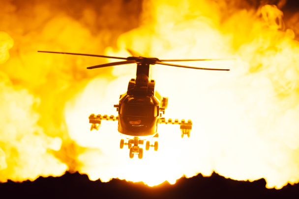 Battle scene with toy helicopter and fire at background - Foto, imagen