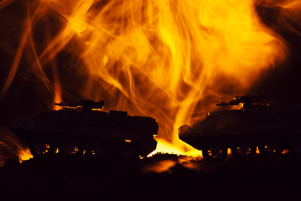 Battle scene with toy tanks and fire on black background - Photo, Image