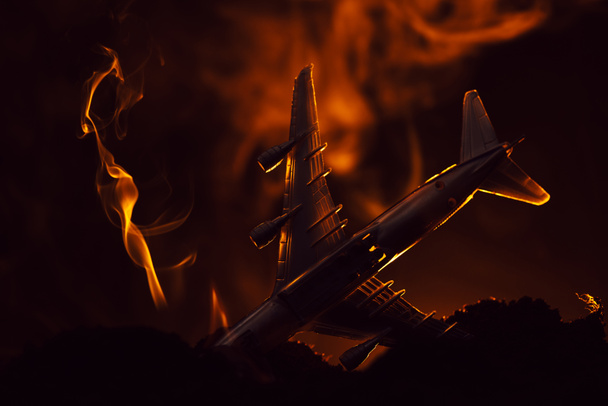 Katastrofa samolotu zabawki z dymem na czarnym tle, scena bitwy - Zdjęcie, obraz