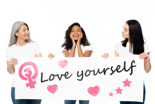 multicultural women holding placard with love yourself lettering isolated on white  - Fotografie, Obrázek