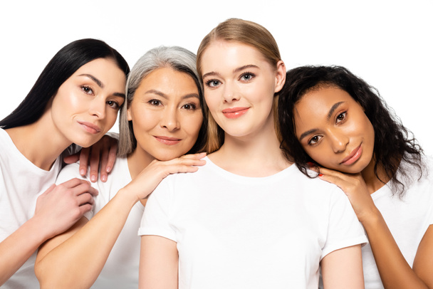 cheerful multicultural women in white t-shirts looking at camera isolated on white  - Foto, immagini