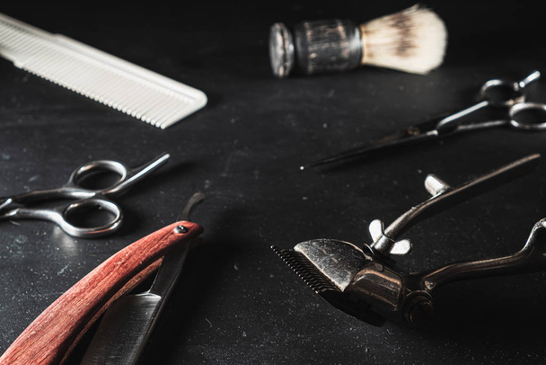 vintage Barber shop equipment on Black background . Professional hairdressing tools. scissor, manual hairclipper, razor, shaving brush, comb - Photo, Image