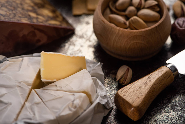 vista ravvicinata del brie di formaggio con coltello, pistacchi
 - Foto, immagini