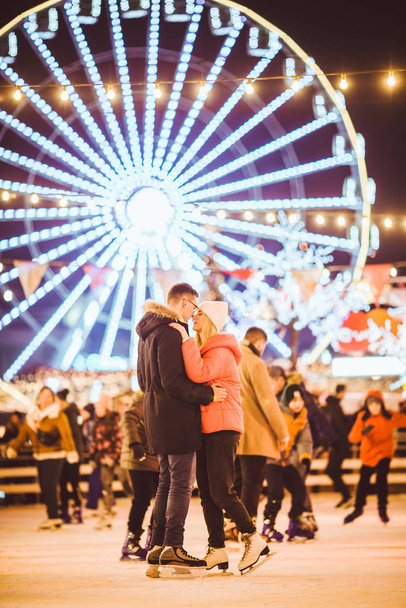 Couple in Love. Romantic Characters for Feast of Saint Valentine. True love. Happy Couple Having Fun at city ice rink in the evening. Happy romantic young couple enjoying together in skating-rink - 写真・画像