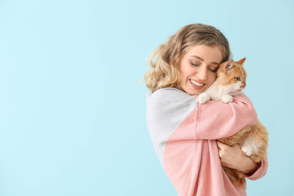 Beautiful young woman with cute cat on color background - Foto, immagini