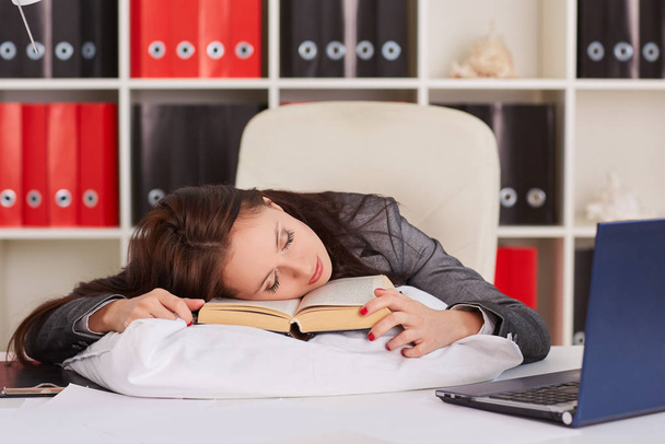 Tired young business woman is sleeping on workplace in the office. - Fotografie, Obrázek
