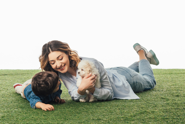 smiling mother holding Havanese puppy and son looking at it isolated on white - Φωτογραφία, εικόνα