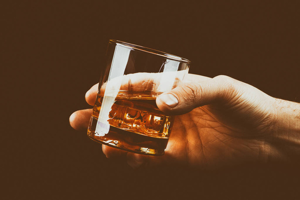 Whiskey glass in a hand of a man - Photo, image