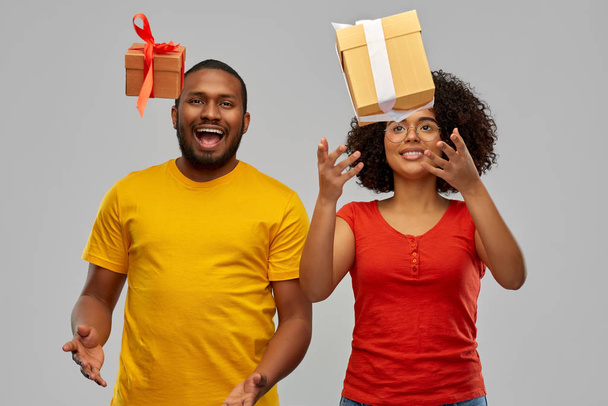 happy african american couple throwing gift boxes - Fotó, kép