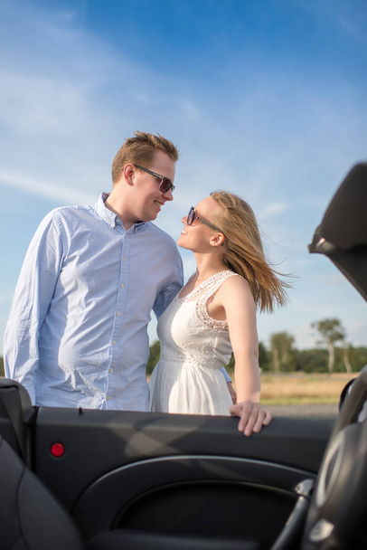 loving couple is on the convertible and looks in love with the eyes - Photo, Image