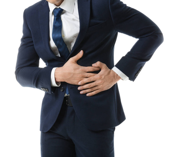 Young businessman suffering from abdominal pain on white background - Photo, Image