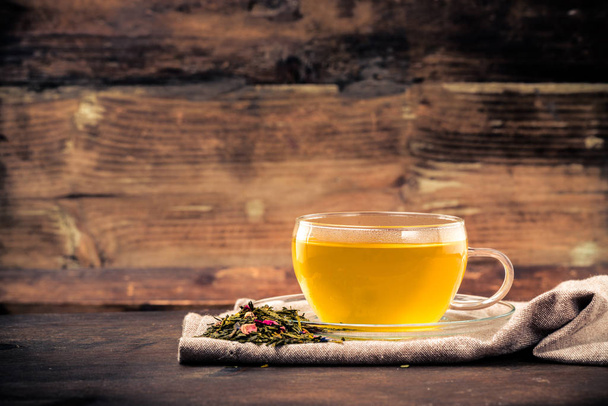 fresh tea with tea leaves and herbs on wood - 写真・画像