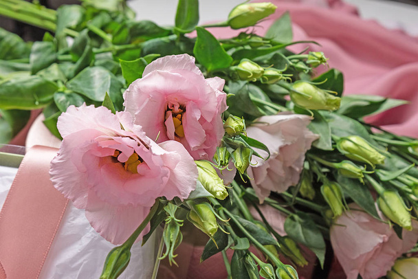 Floral holiday background of eustoma flowers. Buds and flowers of rose without thorns  - Photo, Image