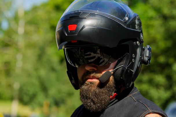 Un uomo con la barba col casco. Primo piano panettiere in un casco nero con barba nera
 - Foto, immagini