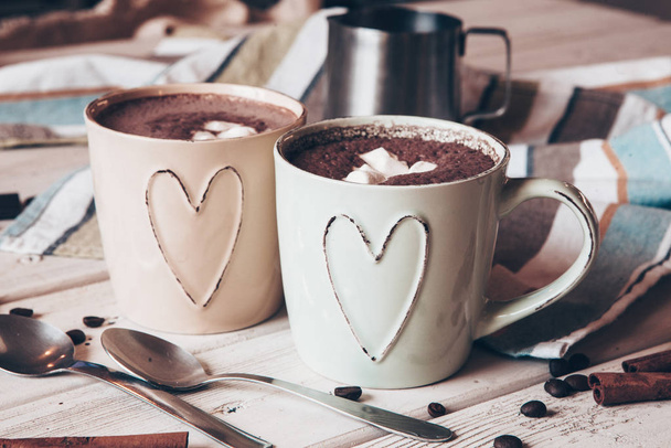 Dos tazas de cacao caliente con malvaviscos y palitos de canela sobre fondo de madera. Amor. Bebida de cacao. Día de San Valentín tratar ideas
. - Foto, imagen