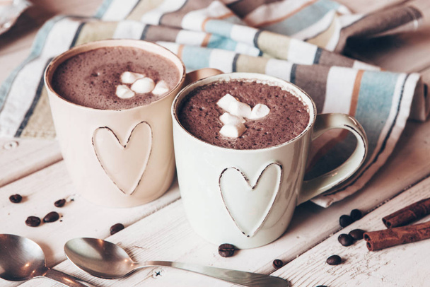 Two cups of hot cocoa with marshmallows and cinnamon sticks on wooden background. Love. Cocoa drink. Valentines day treat ideas. - Photo, Image